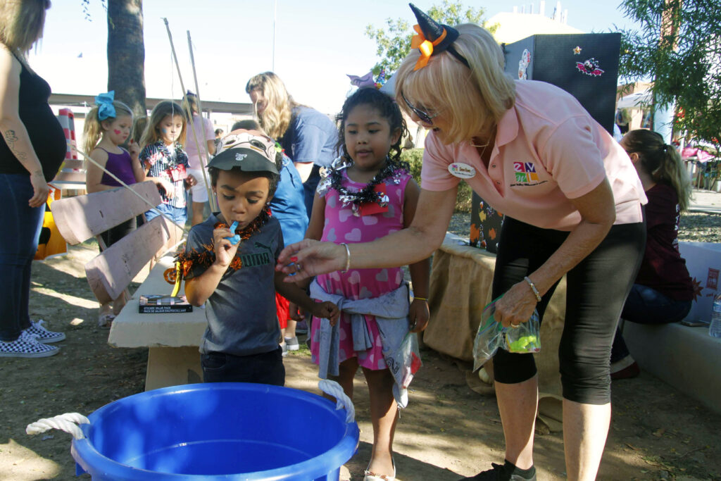 Image of woman volunteer helping kids during a Maggie's Place event